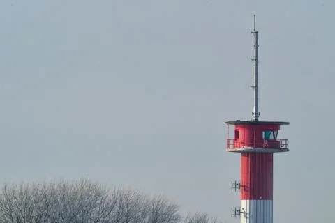 Red and white communication tower with antennas against clear sky and frost.. Stock Photos