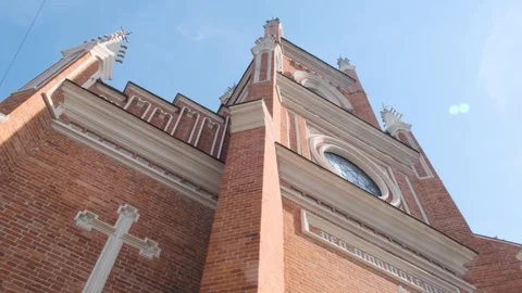 The red and white facade of a Catholic church against a blue sky Stock Footage 123426965