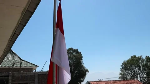 The red and white flag flies on the school yard pole Stock Footage 282572350