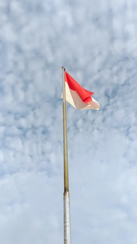 Red and white flag under white clouds Stock Footage 309659475