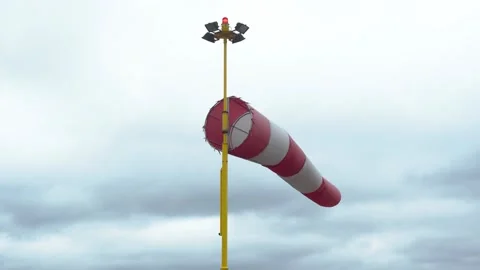 Red and White Flag. Windsock flutters in a strong wind showing wind direction Stock Footage 186185247