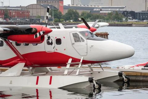 Red and white floatplane next to a pier Stock Photos