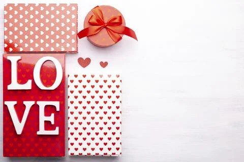 Red and white gift boxes with hearts Love wooden word on grey stone background, Stock Photos