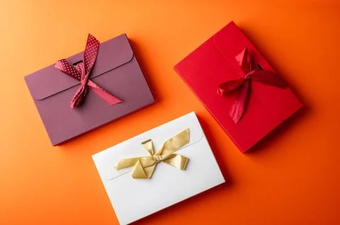 Red and white gift boxes on orange color background Foto stock