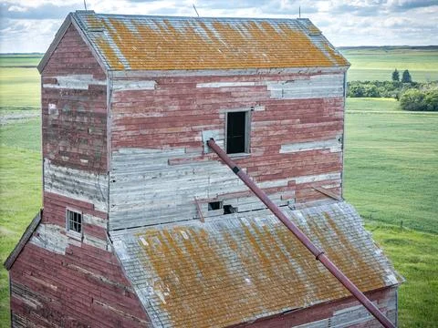 Red and white grain elevator with a slanted roof Stock Photos