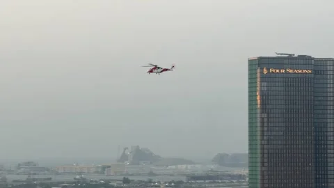 Red and white helicopter flying over modern city skyline Stock Footage 340407127