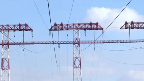 Red and white high-voltage power line towers against the sky Stock Footage 323222432