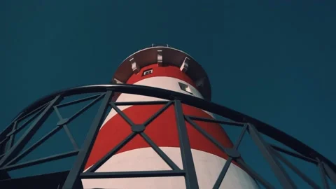 Red and white lighthouse against a clear blue sky. Bottom view. Close-up. Stock Footage 147405372