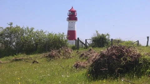 Red and white lighthouse standing tall in green meadow near Kappeln in Germa Stock Footage 297812088
