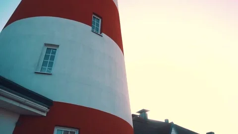 A red and white lighthouse from which the sun shines on an autumn day. Close-up. Stock Footage 147405549