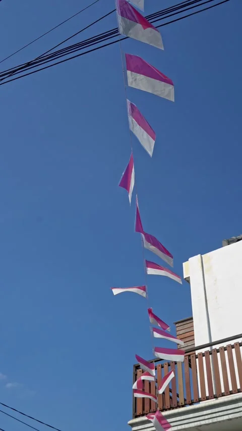 Red and white national flags hanging on a string line against a bright blue.. Stock Footage 344361570