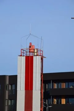 Red and White Navigation Beacon Tower Rising Above Modern Stock Photos