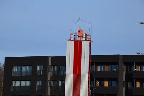 Red and White Navigation Beacon Tower Rising Above Modern Foto stock