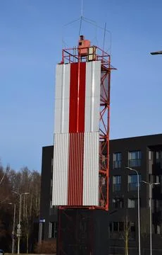 Red and White Navigation Beacon Tower Rising Above Modern Stock Photos