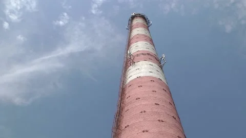 Red and white old brick industrial pipe against the blue sky Video stock 112018073