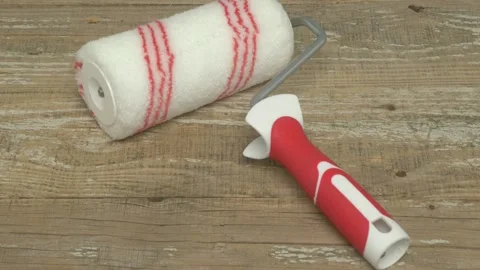 Red and White Paint Roller Being Used on a Wooden Surface for a Home Improvement 動画素材 281411372