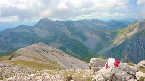 Red and white painted stripes on big stone in mountains peak, hiking important 스톡 동영상 224776131