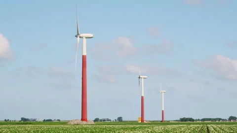 Red and white painted wind turbines in an agricultural field Stock Footage 246752054