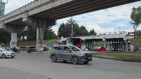 Red and white public bus turning at Paseo Tollocan loop, zoom out view Stock Footage 337189693