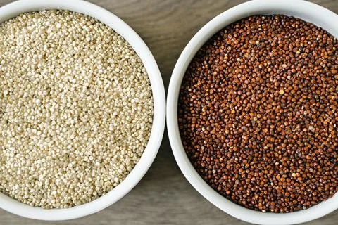 Red and white quinoa on the two white plates Stock Photos