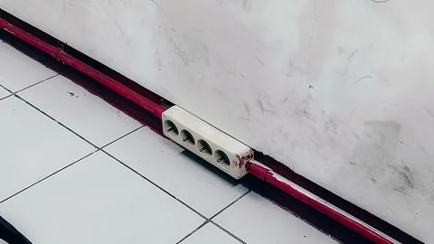 A red and white striped object is on the floor Stock Photos