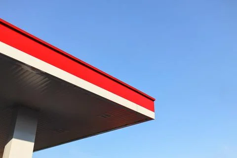 Red and white striped rooftops against a blue sky. Stock Photos