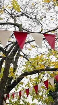 Red and white triangular bunting hanging against a background of bright yel.. 스톡 사진