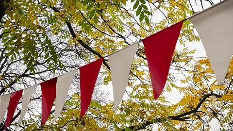 Red and white triangular bunting hanging against a background of bright yel.. 写真素材