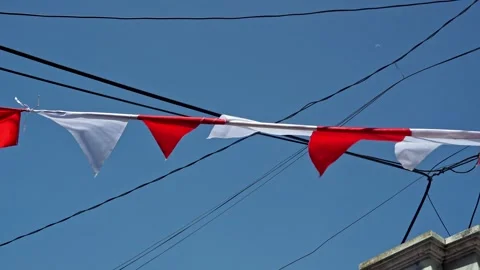 Red and white triangular festive flags hanging under power lines, symbolizi.. Stock Footage 344355864