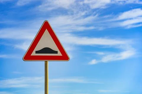 Red and white triangular warning road sign with a warning of a bumpy road Stock Photos