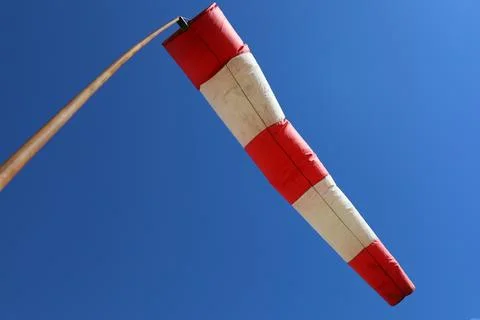 Red and white wind indicator on the background of a blue sky Stock Photos