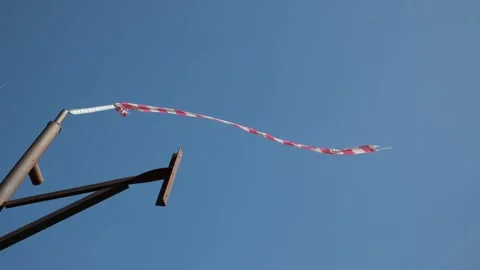 Red and white wind sock against clear blue sky Stock Footage 306490072