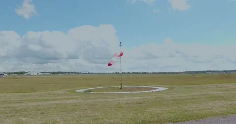 Red and white windsock on airfield under cloudy sky Stock Footage 340206351
