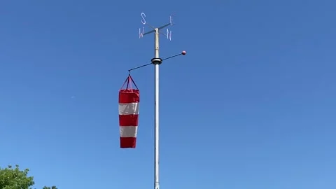 Red and white windsock on metal pole measuring wind direction. Video stock 339004065