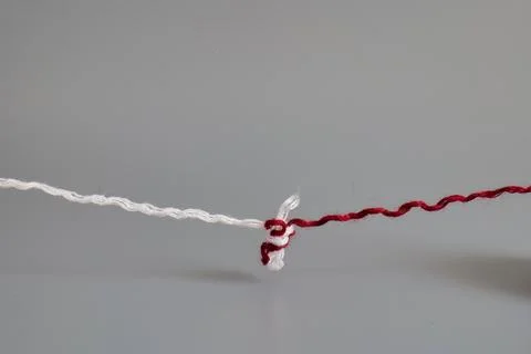 Red and white yarn threads forming connection knot Stock Photos