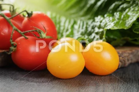 Red And Yellow Cherry Tomatoes With Salad Leaves