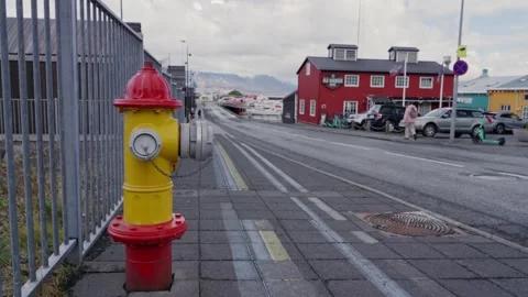 Red and yellow fire hydrant. Reykjavik, Iceland - April 27, 2025 Stock Footage 310743011
