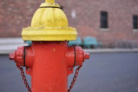 Red and yellow fire hydrant with brick background Stock Photos