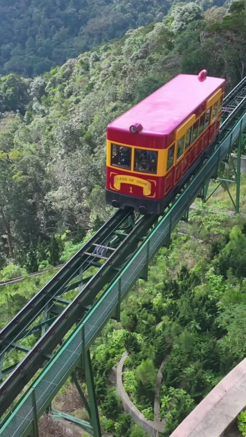 A red and yellow funicular train travels through Ba Na Hills, Vietnam. Stock Footage 333356810