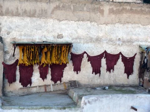 Red and yellow hides drying in Moroccan city Fes Foto stock