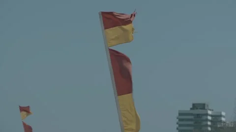 Red And Yellow Lifesaving Flags Blowing In Wind On Sunshine Coast Beach Australi Stock Footage 341285558