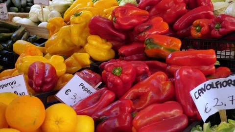 Red and yellow peppers displayed on Italian market vegetable stall outdoors Stock Footage 334776379