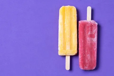 Red and yellow popsicles pattern on purple background Stock Photos
