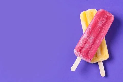 Red and yellow popsicles pattern on purple background Stock Photos