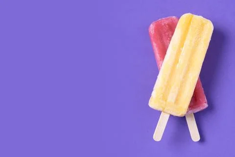 Red and yellow popsicles pattern on purple background Stock Photos