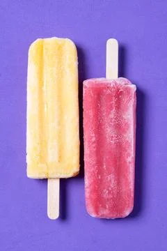 Red and yellow popsicles pattern on purple background Stock Photos