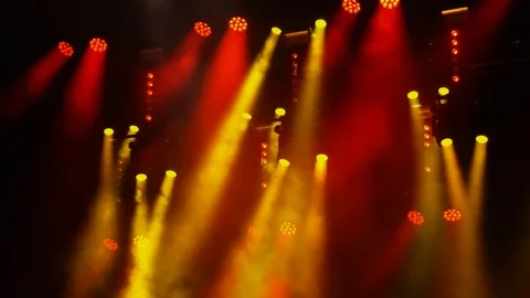 Red and yellow spotlights flash in the fog at a rock concert in the dark. Video stock 111140706