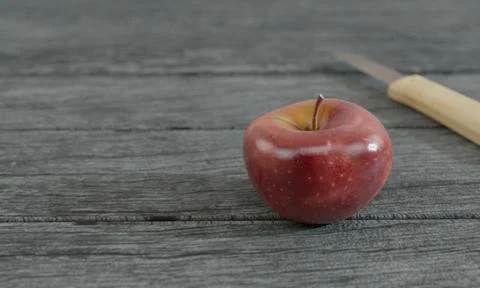 Red apple and blur small knife wood handle on gray wooden surface by 3D rende Stock Illustration