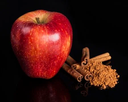 Red apple and cinnamon on reflection surface Stock Photos