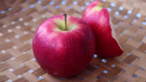 Red apple and slices rotating on wicker tray Stock Footage 139856568